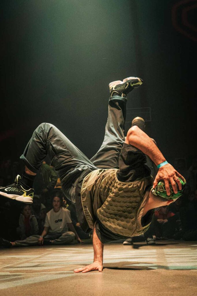 Un danseur de breakdance fait une figure spectaculaire en se tenant sur une seul main. Romain VIDAL - Vidéaste & Photographe - Clermont-Ferrand