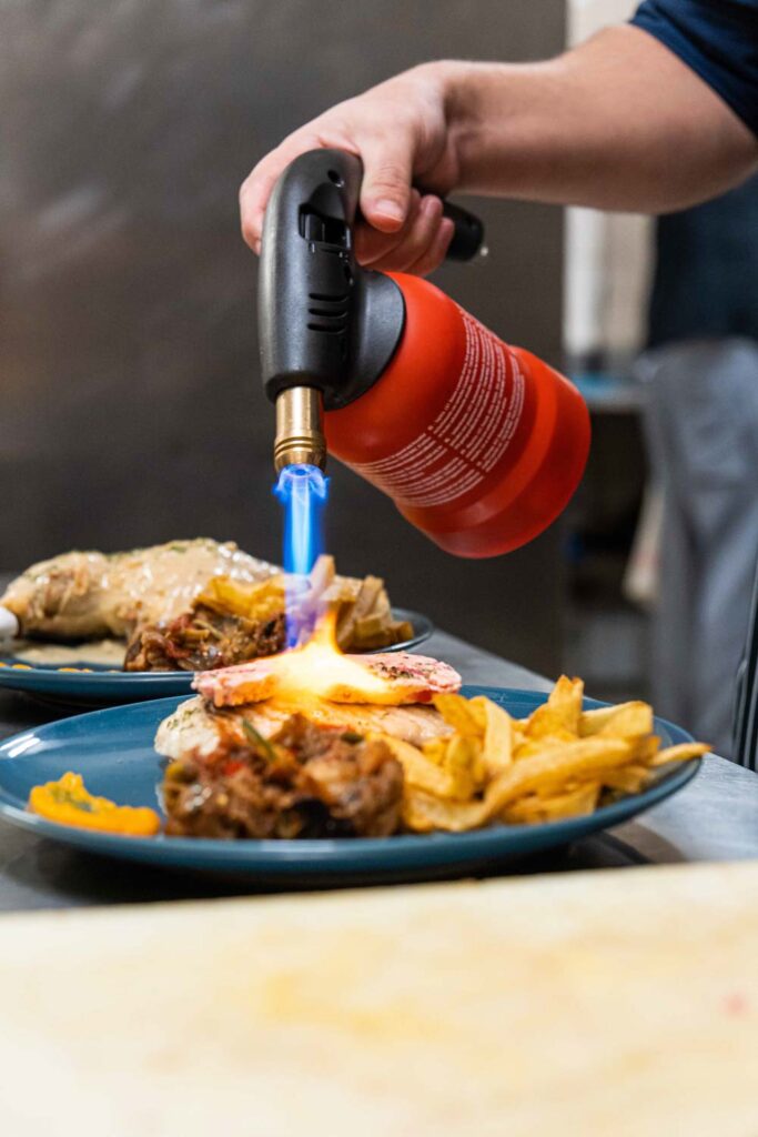 Plat poulet frite en train d'être doré au chalumeau